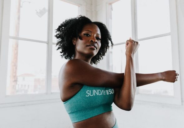 a woman in a sports bra top stretching her arms