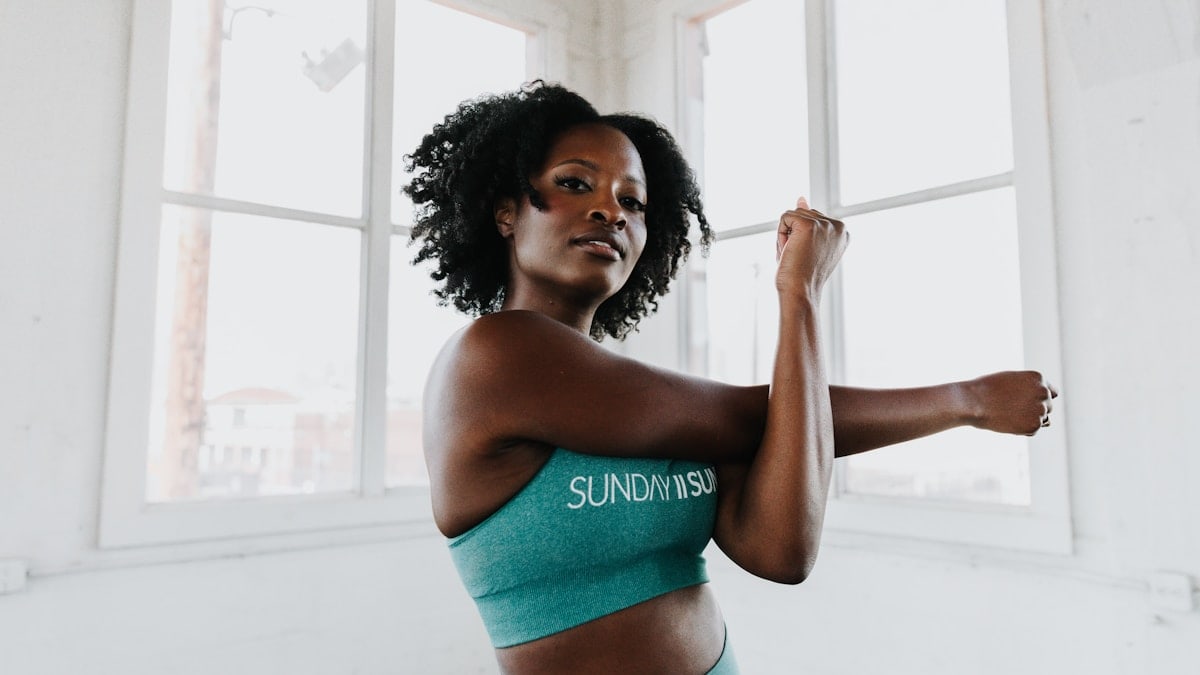 a woman in a sports bra top stretching her arms